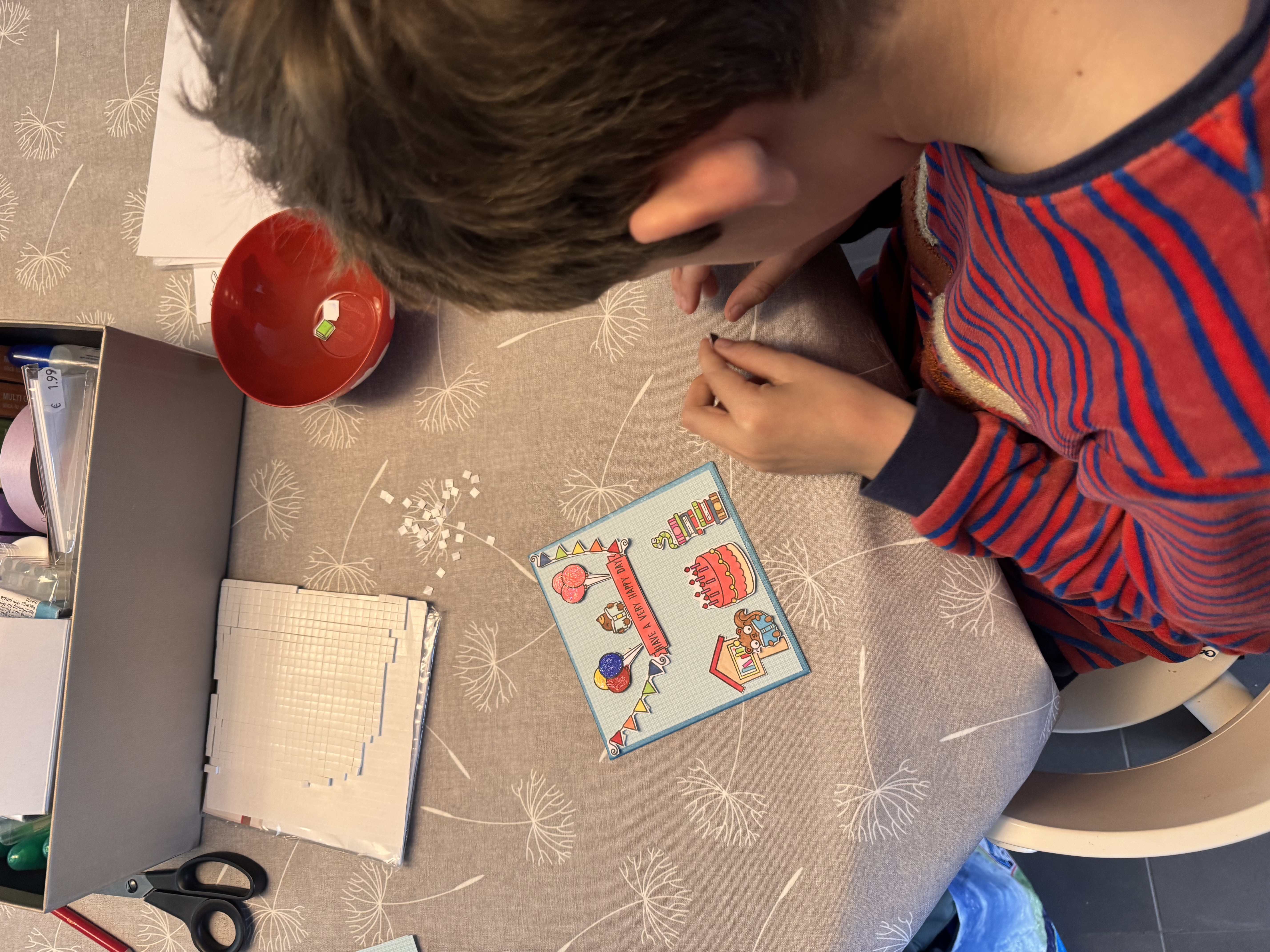 Jongen die eigen kaartje knutselt